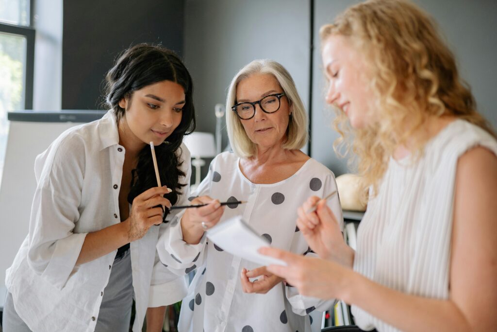 A diverse team of women engaged in a productive office meeting, working together with focus and dedication.